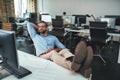 Time to relax. Handsome bearded young man in eyeglasses and formal wear holding hand behind his head and keeping legs on Royalty Free Stock Photo