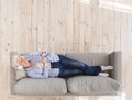 Senior Woman Listening Music In Headphones While Relaxing On Couch With Smartphone Royalty Free Stock Photo