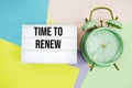 Time To Renew text in lightbox with alarm clock on pastel background Royalty Free Stock Photo