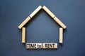 Time to rent house symbol. Concept words `Time to rent` on wooden blocks near miniature house. Beautiful grey background, copy Royalty Free Stock Photo