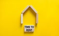 Time to rent house symbol. Concept words `Time to rent` on wooden blocks near miniature house. Beautiful yellow background, copy Royalty Free Stock Photo