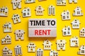 Time to rent house symbol. Concept words `Time to rent` on wooden blocks near miniature houses. Beautiful yellow background, cop Royalty Free Stock Photo