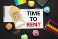 Time to rent real estate symbol. White note, words `time to rent` on beautiful black background, metalic pen, calculator, colore