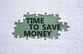 Time to save money symbol. White puzzle with words Time to save money. Beautiful grey green background. Business and Time to save Royalty Free Stock Photo