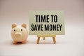 Time to save money text message and piggy bank on pink background Royalty Free Stock Photo