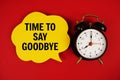Time to say Goodbye text on speech bubble with alarm clock on red background Royalty Free Stock Photo