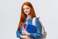 Time to school. Lovely cheerful modern redhead female with backpack holding notebooks heading college, smiling amused Royalty Free Stock Photo