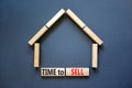 Time to sell house symbol. Concept words `Time to sell` on wooden blocks near miniature house. Beautiful grey background, copy Royalty Free Stock Photo