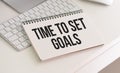 TIME TO SET GOALS text written on a notebook on grey background with chart and keyboard , business concept