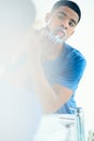 Time to shave this all off. Shot of young man shaving his face in his bathroom mirror. Royalty Free Stock Photo