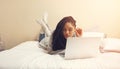 Time to sleep, oh look, another episode. a young woman using her laptop while lying in her bedroom.