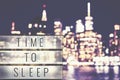 Time to sleep text in a lightbox, blurred Manhattan at night. Royalty Free Stock Photo