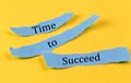 TIME TO SUCCEED text on a blue pieces of paper on yellow background, business concept