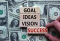 Time to success. Wooden blocks form the words `goal, ideas, vision, success` on beautiful background from dollar bills. Male han