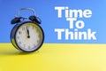 TIME TO THINK inscription written and Alarm Clock on blue yellow background Royalty Free Stock Photo