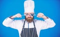 Time to try taste. Chef serious strict face hold spoon and fork. Man handsome with beard holds kitchenware on blue