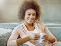 Time to unwind with some tea. Portrait of a young woman relaxing with a warm beverage at home.