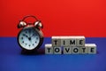 Time to Vote alphabet letter with alarm clock on blue and red background