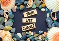 Time to your last chance symbol. Concept words Your last chance on wooden blocks on a beautiful black table black background. Sea Royalty Free Stock Photo