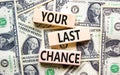 Time to your last chance symbol. Concept words Your last chance on wooden blocks on a beautiful background from dollar bills. Royalty Free Stock Photo