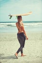 Time for a water adventure. a beautiful young woman going for a surf at the beach.