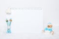 Time for winter holidays. Blank notepad, teddy bear with snowballs, toy wooden blue skis and white hat on snowy Royalty Free Stock Photo