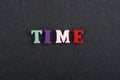 TIME word on black board background composed from colorful abc alphabet block wooden letters, copy space for ad text. Learning Royalty Free Stock Photo