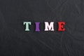 Time word on black board background composed from colorful abc alphabet block wooden letters, copy space for ad text Royalty Free Stock Photo