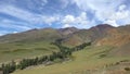 Timelaps of Kuray mountain range with Tydtuyaryk river andrunning clouds on blue sky