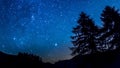 Timelapse night sky stars. Mountain and trees silhouette