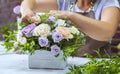 Timelapse professional florist arranging flower composition in wooden box in floral design studio