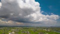 Timelapse tilt up on large cumulous cloud moving over rural landscape