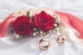 Timeless love Wedding rings on white and red roses backdrop Royalty Free Stock Photo