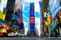 Times Square with yellow New York City Taxi cabs and tour buses driving through colorful billboards. Royalty Free Stock Photo