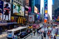 Times Square with yellow New York City Taxi cabs and tour buses driving through colorful billboards. Royalty Free Stock Photo