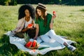 Timespending of two multi-ethnic girl friends.Pretty african girl is chatting via the mobile and eating the watermelon Royalty Free Stock Photo