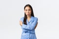 Timid and upset sulking cute asian girl in blue pajamas feeling insecure and distressed, pouting offended, hugging Royalty Free Stock Photo