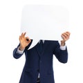 Timid young businessman in navy blue covering face with speech bubble