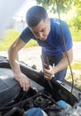 Timing belt break. Man near hood of car is looking for a malfunction due to which the engine does not work. Driver is holding a Royalty Free Stock Photo