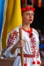 Young girl Ukrainian dancer in traditional costume, with national flag