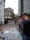 Timisoara / Romania - October 13, 2019: a young man looks at paintings painted by spray can. The paintings are sold by a freelance