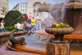 Timisoara - Pansies in a stone flower pot at the Fish Fountain with people enjoying their walk in the background