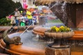 Timisoara - Pansies in a stone flower pot at the Fish Fountain with people enjoying their walk in the background Royalty Free Stock Photo