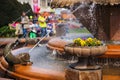 Timisoara - Pansies in a stone flower pot at the Fish Fountain with people enjoying their walk in the background