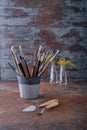 In a tin bucket, different in shape and size brushes for oil painting with natural bristles.