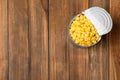 Tin can with conserved corn on wooden background