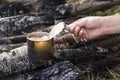 Tin can on the fire. Reheating meat at a picnic