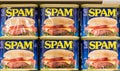 Tin cans of Spam Brand meat in a supermarket aisle