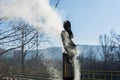 Winter Rooftop: Tin Chimney Emitting Smoke on a Sunny Day