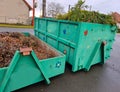 tin container for storing biowaste from a gardening company branches of leaves and cut grass open iron painted Royalty Free Stock Photo